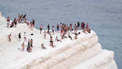 A sea breeze brings some relief to bathers at the Scala dei Turchi on the coast of Realmonte, near Porto Empedocle, Sicily, Italy. AP