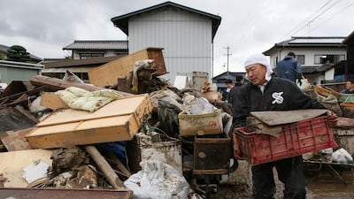 A man removes muddy items from the flood-damaged homes in Nagano, after Typhoon Hagibis hit Japan on October 12 unleashing high winds, torrential rain and triggered landslides and catastrophic flooding. Rescuers in Japan worked into a third day in an increasingly desperate search for survivors of a powerful typhoon that killed nearly 70 people and caused widespread destruction. AFP