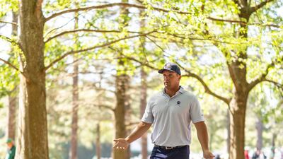 Bryson DeChambeau discusses his second shot out of the rough with his caddie on the 13th fairway at Augusta. EPA