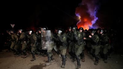 Ukrainian law enforcement officers clear the way as demonstrators block a road during a protest against the arrival of a plane carrying evacuees from coronavirus-hit China. Reuters