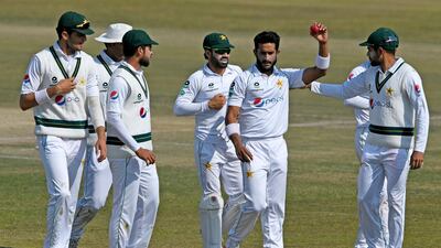 Pakistan's Hasan Ali holds the ball as his teammates congratulate him after he took five wickets at the end of the South Africa's innings during the third day of the second Test in Rawalpindi on February 6, 2021. AFP