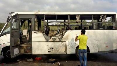 An Egyptian man inspects damage on a bus after a missile attack in North Sinai's capital El Arish. Three factory workers were killed and more than a dozen were injured.