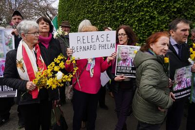 Campaigners attending the protest held yellow flowers and banners. PA