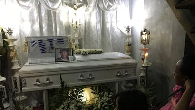 Coffin of Noel Salamat, watched by his wife Khrisna. (Colin Freeman for The National)