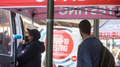 A man is given a Covid-19 test at a pop-up site on a pavement in New York City. Reuters