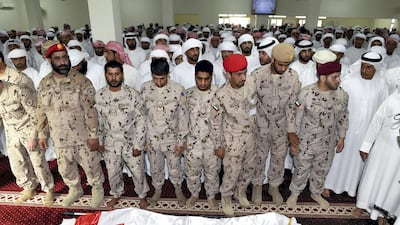 Men perform funeral prayers over the body of Warrant Officer Mohammed Saeed Al Hassani who was killed in a helicopter crash in Yemen. Wam