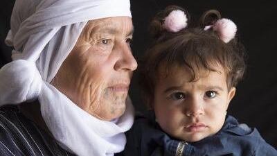 Mayre Hame, 65 or 66 year-old woman from Bir Rame, a village of Kobani, with her one-year- old granddaughter Lina. She is the mother of 11 children. ‘My mother died when I was just 10 years old. Me and my three sisters all got tattoos. I was scared.’