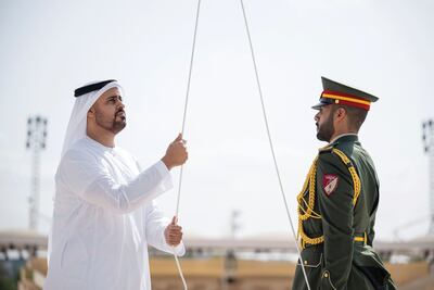Sheikh Theyab bin Mohamed bin Zayed Al Nahyan, Deputy Chairman of the Presidential Court for Development and Fallen Heroes' Affairs, raises the UAE flag following a silent prayer at Wahat Al Karama, Abu Dhabi on Saturday. Wam