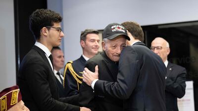 Mr Macron embraces veteran Buddy Reynolds after awarding him the Legion d'Honneur. Mr Reynolds, who is 101, attributes his long life to a dedication to 'service for others'. AFP