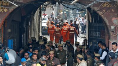 Members of India's National Disaster Response Force (NDRF) head towards the site of a fire that swept through a factory where laborers were sleeping, in New Delhi, India. Reuters