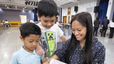 A family is happy to pick up their tickets for the Papal mass.