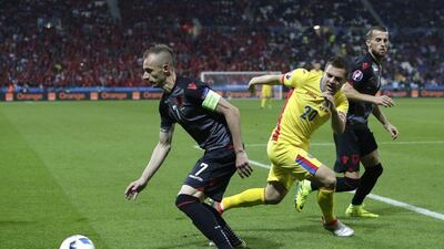 Romania's Adrian Popa, centre, and Albania's Ansi Agolli vie for the ball. Pavel Golovkin / AP Photo