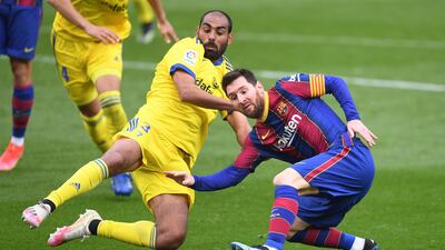 Barca's Lionel Messi is challenged by Fali of Cadiz. Getty