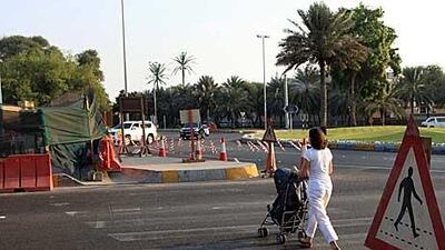 Daisy Gardener and her six-month-old son, Thomas, cross 13th Street in Abu Dhabi.