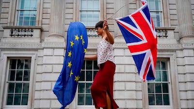 An anti-Brexit demonstrator whirls an EU and Union Flag during a demonstration against the British government's move to suspend parliament in the final weeks before Brexit outside Downing Street in London on August 31, 2019. Demonstrations, being dubbed "Stop The Coup" by organisers, were to be held across Britain on August 31 against Prime Minister Boris Johnson's move to suspend parliament in the final weeks before Brexit. The protests come ahead of an intense political week in which Johnson's opponents will seek to block the move in court and legislate against a no-deal departure from the European Union. / AFP / Niklas HALLE'N
