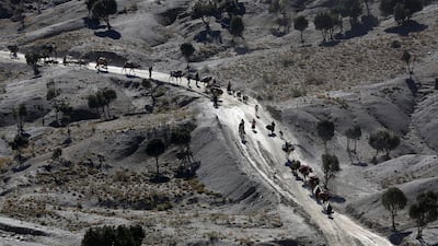 Afghans walk with camels on a dusty road near the town of Walli Was in Paktika province, near the border with Pakistan November 3, 2012. Reuters