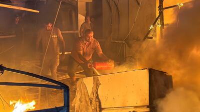 Survivors fight a fire after an Israeli attack on a tent camp for displaced people in Deir Al Balah. Reuters