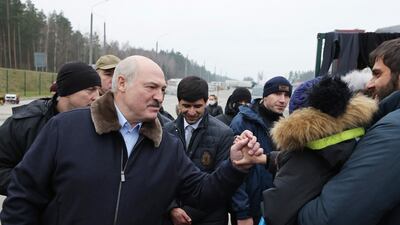 Belarusian President Alexander Lukashenko shakes the hand of a migrant child at the Belarus-Poland border. AP