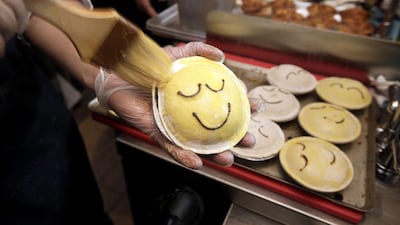 A baker brushes on a glaze on pies before baking at Pie Face in New York. Pie Face has 665 outlets signed up for expansion across Japan, South Korea and the Philippines. Richard Drew / AP Photo