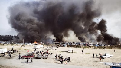 Smoke billows from the camp near Calais after tents and shelters were set ablaze on October 26, 2016. Etienne Laurent/EPA
