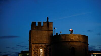 A man plays a bugle to signify the start of a minute of silence ahead of torches being lit for the installation 'Beyond the Deepening Shadow' at the Tower of London. Reuters
