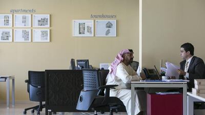 Saeed Al Haj Al Kaabi, left, from Al Ain talks with Mohammed Al Tabaa, a sales and leasing supervisor at Khidmah, as he negotiates a purchase of several units at Aldar’s Alghadeer project. Silvia Razgova / The National
