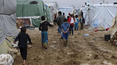Syrian refugee children walk in mud at a refugee camp in the town of Hosh Hareem. (Hassan Ammar / AP)