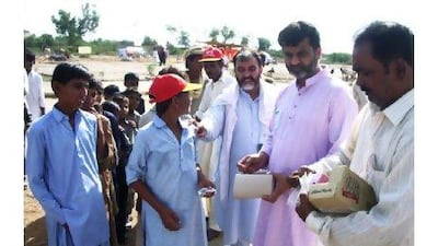 Rizwan Fancy, the community welfare secretary for Pad, second from right, hands out aid to people in the flood-hit Sindh province in Pakistan during Eid Al Adha.
