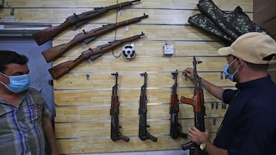 Employees display rifles for sale at a gun shop in the Iraqi capital Baghdad. AFP
