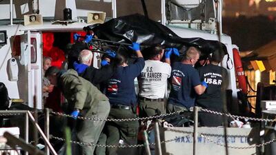 Rescue personnel return to shore with the bodies of 25 victims. Reuters