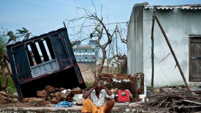 Bhagwan, a coconut-seller, sits in front of his destroyed shop in Gopalpur after Cyclone Phailin left a trail of destruction along India's east coast. Manan Vatsyayana / AFP