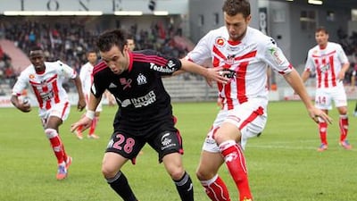 Marseille's Matthieu Valbuena vies with Samuel Bouhours during the match with Ajaccio