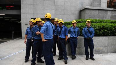 Emergency services personnel wait as Robert climbs the building. AFP
