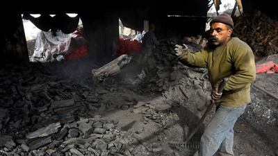 A worker sorts charcoal at a plant in the West Bank village of Yabed. Over the past years, Yabed has been considered as the economic capital of the Palestinians for producing charcoals. Alaa Badarneh / EPA