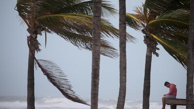 A man sits on a lifeguard tower as Hurricane Irma blows into Florida. Carlo Allegri / Reuters