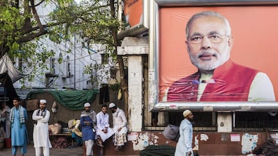 Pedestrians walk past a billboard for the Bharatiya Janta Party picturing its prime ministerial candidate Narendra Modi as the third phase of voting for national elections commences in New Delhi, India, on Thursday, April 10, 2014. Prashanth Vishwanathan / Bloomberg