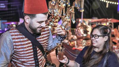 A visitor is served some Syrian tamarind juice. Victor Besa / The National 