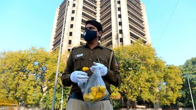 A policeman holds flowers to distribute to people in a bid to inspire them to stay home. AFP