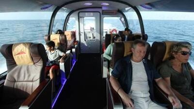 Tourists are seated comfortably while travelling on board a Dubai water taxi.