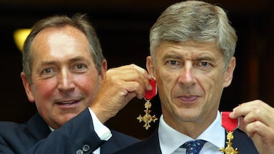 Pictured on July 9, 2003 Gerard Houllier (L) of Liverpool holds his OBE medal as an earring on long-term friend and fellow manager Arsene Wenger of Arsenal, after being awarded their OBE medals at The Foreign Office in London. Adrian Dennis / AFP