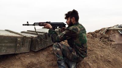 A pro-Assad gunman holds a position at a military airport held by Syrian troops and pro-regime militias in the northeastern Syrian city of Deir Ezzor on December 12, five days after they repelled an attack by militants. AFP Photo