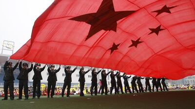 People's Liberation Army soldiers wave a Chinese national flag at a stadium in Beijing. Kevin Zhao / Reuters