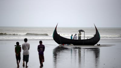 People look at a boat that capsized with a group of Rohingya refugees in it at Bailakhali, near Cox's Bazar, in Bangladesh on October 31, 2017. Hannah McKay / Reuters