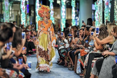 A model sports an elaborate head dress crafted from flowers in Dolce & Gabbana's Dubai Mall show. Victor Besa / The National
