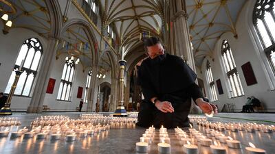 A verger lights one of 4,161 candles representing each death from Covid-19 in Lancashire county, following a service by Dean of Blackburn, Peter Howell-Jones at Blackburn Cathedral. AFP