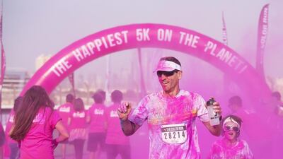 Participants in the Colour Run Dubai - sponsored by Activelife - pass through the final colour station on the way to the finish line of the 5k fun run at the Autodrome. Clint McLean for The National