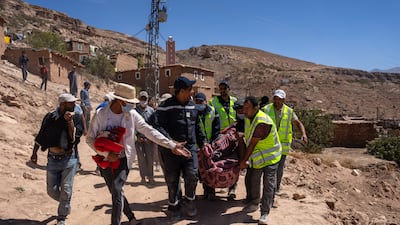The body of a man is carried for burial after being removed from the rubble of a collapsed house in Douzrou. Getty Images