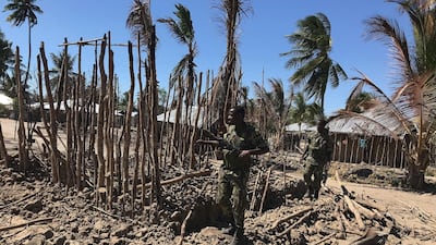 Mozambican Army soldiers bring down a structure torched by attackers to be rebuilt as shelter for people fleeing the recent attacks, in Naunde, northern Mozambique. AFP