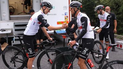 Tadej Pogacar shakes hands with a teammate before taking part in a team training session. AFP