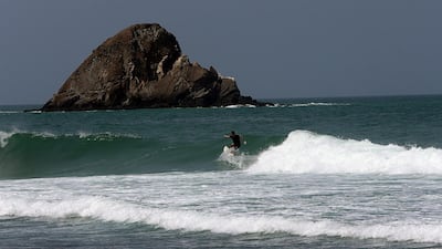 A surfer hits the waves off Snoopy Island in Al Aqah, Fujairah. Satish Kumar / The National